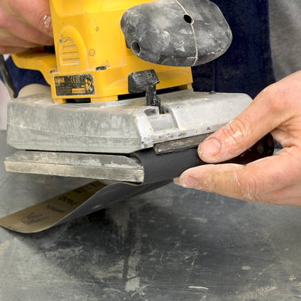Abrasive Paper Being Fitted to an Orbital Sander