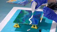 Christine pouring white resin to create wave details Thumbnail